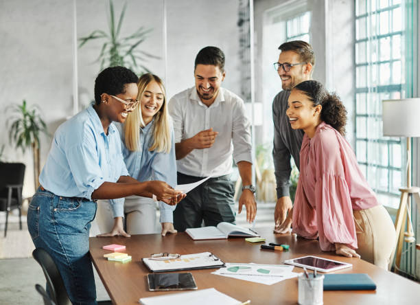 Professionnels souriants en pleine discussion autour d’une table, avec bloc-notes et surligneurs, symbolisant la collaboration dans un coaching d’anglais professionnel. Cette image reflète les situations abordées dans le Business English Coaching : présentation en contexte multiculturel, négociation pour entrepreneurs, communication technique pour les professionnels de la tech, et préparation aux entretiens pour étudiants et chercheurs d’emploi."